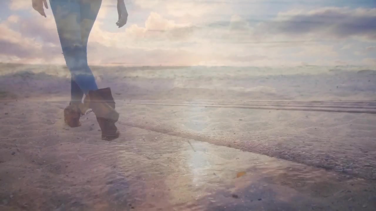 Walking female in fitted jeans, ankle boots moving along wet shoreline, sun reflection, copy space