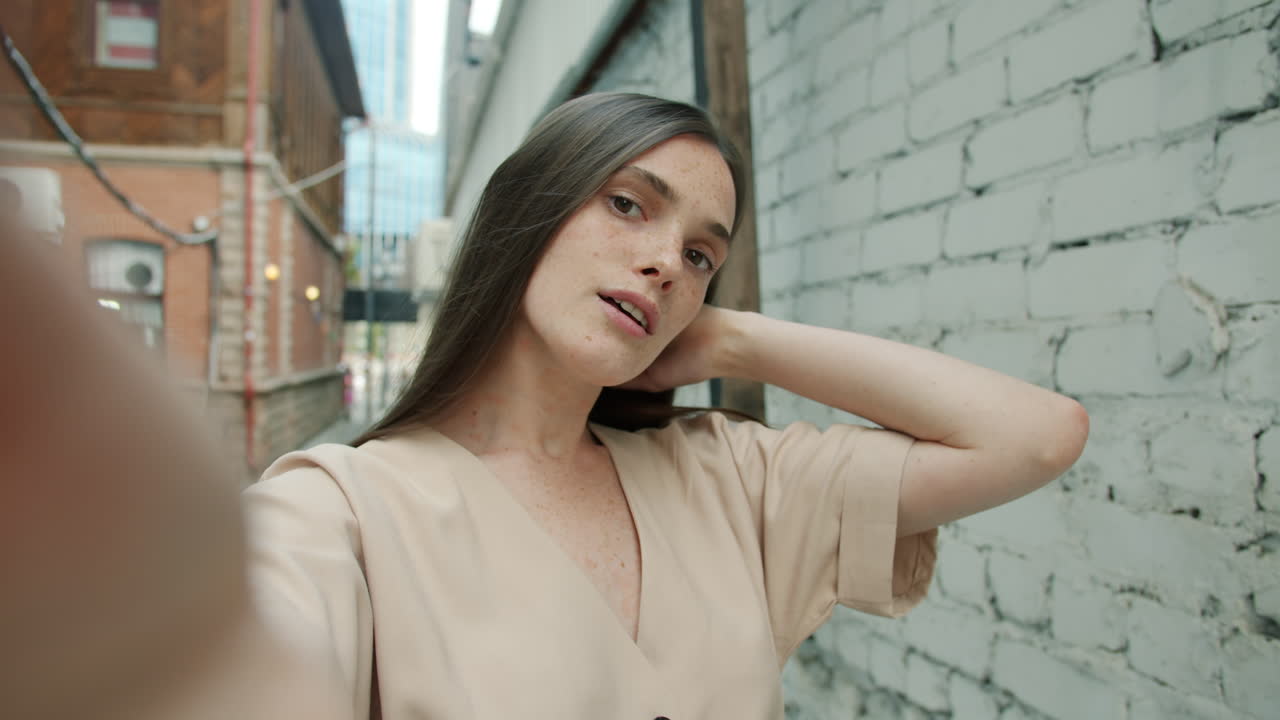 Woman taking a selfie in a city alley