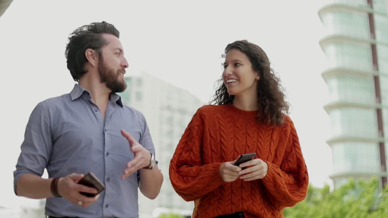 pareja con teléfonos inteligentes y hablando al aire libre