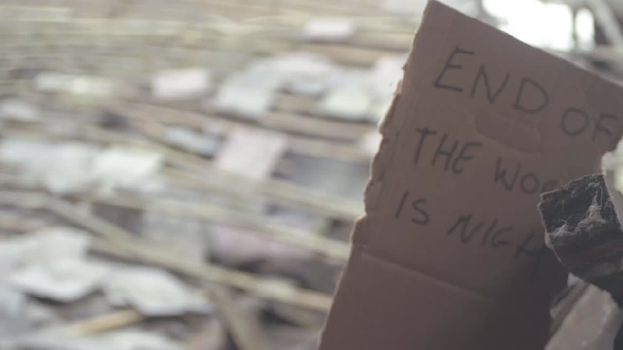 End of the world handwritten sign blowing in the breeze of building rubble