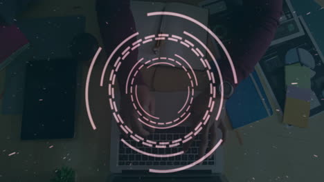 circular digital interface animation over person typing on laptop at desk