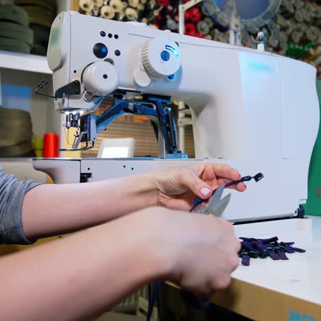 hand sewing material by machine. professional seamstress in textile factory sewing with industrial sewing machine at garment