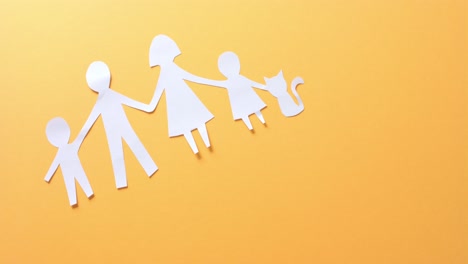 Close-up-of-family-with-cat-made-of-white-paper-on-yellow-background-with-copy-space