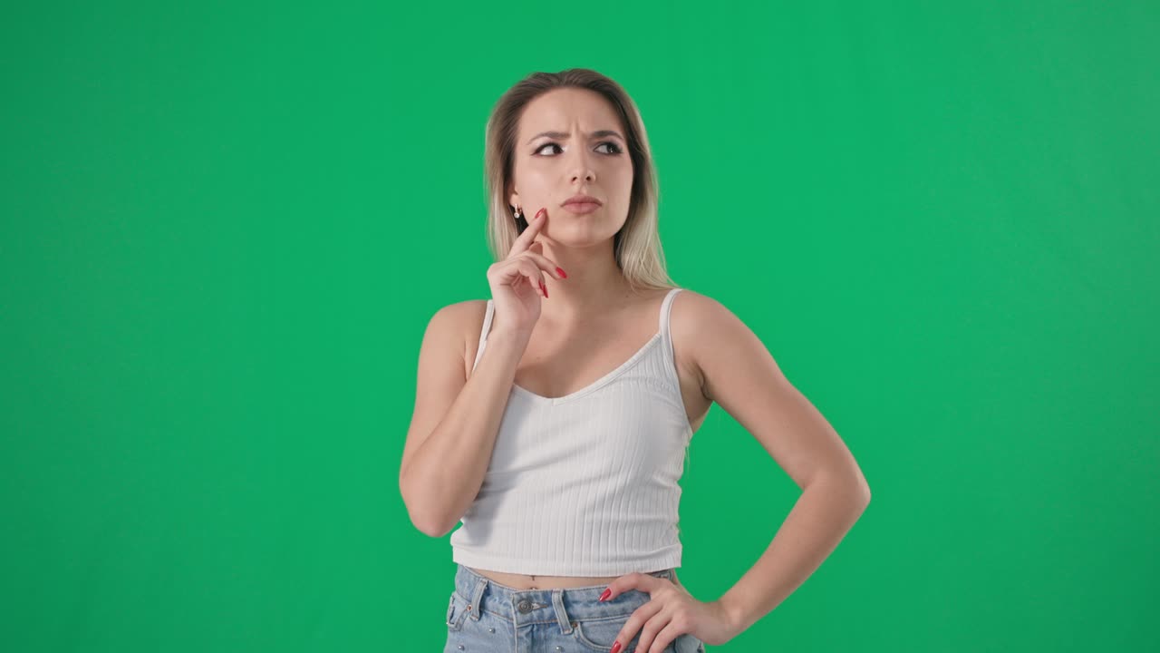 retrato pensativa mujer joven encantadora con cabello largo apunta hacia arriba y gira la cabeza sobre un fondo verde, llave cromada