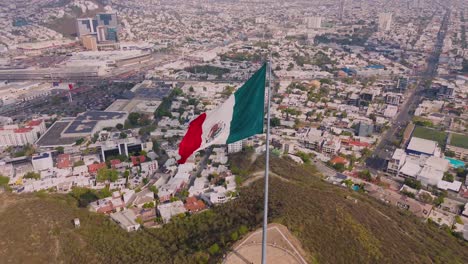 Bandera-Mexicana-En-Un-Día-Ventoso-En-Una-Ciudad-Del-Norte-De-México-Yendo-Hacia-Atrás