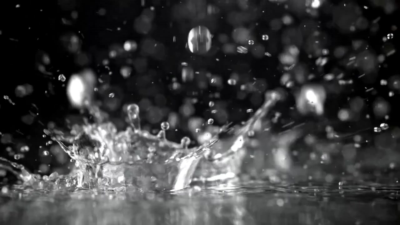Slow Motion Water Drops Splashing on a Dark Surface