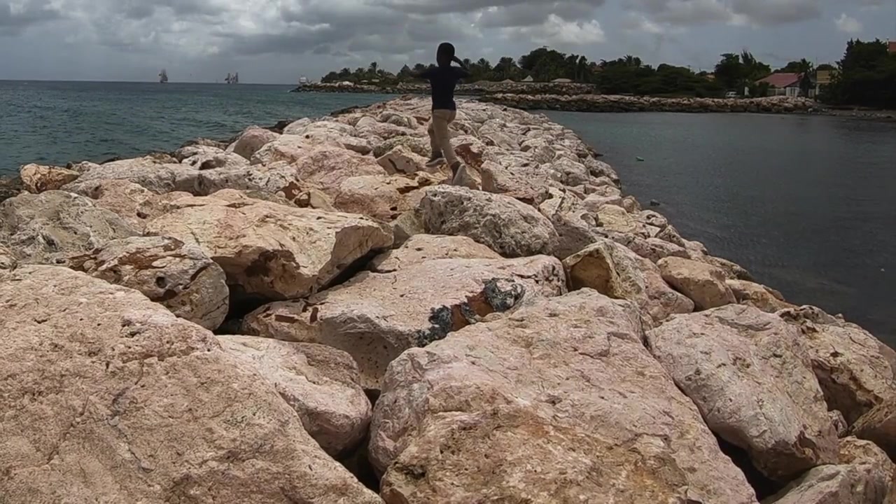 Místní chlapec kráčející po vlnolamu