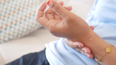 la mano de una mujer con un brazalete de oro