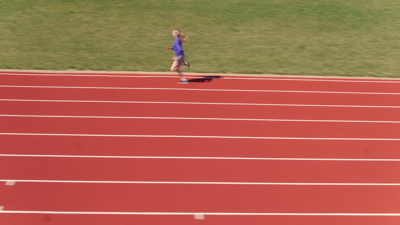 jovencita en pista corriendo rápido con seguimiento de cámara para seguir