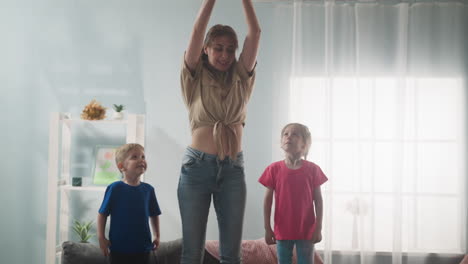 Woman-lifts-piggy-bank-over-head-with-kids-in-living-room