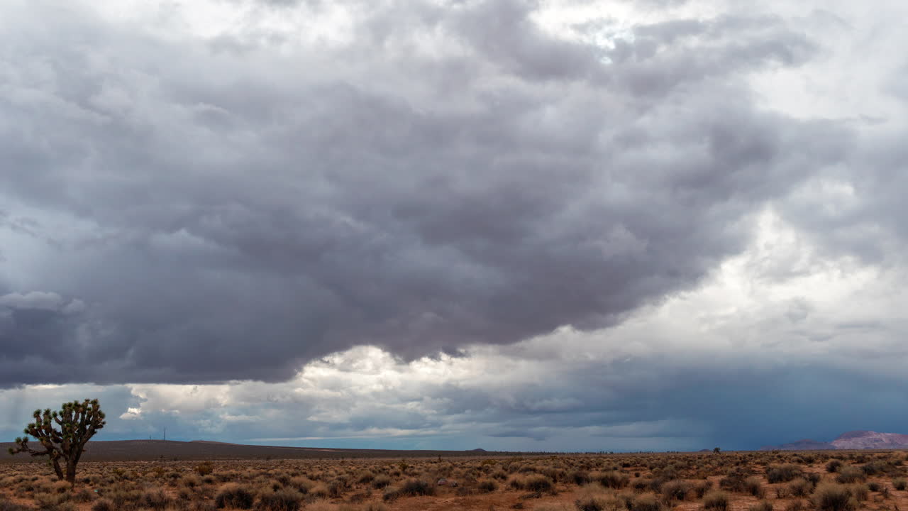 Nuvole di pioggia che formano figure astratte sul paesaggio arido e assetato del deserto del Mojave - time lapse a sviluppo rapido