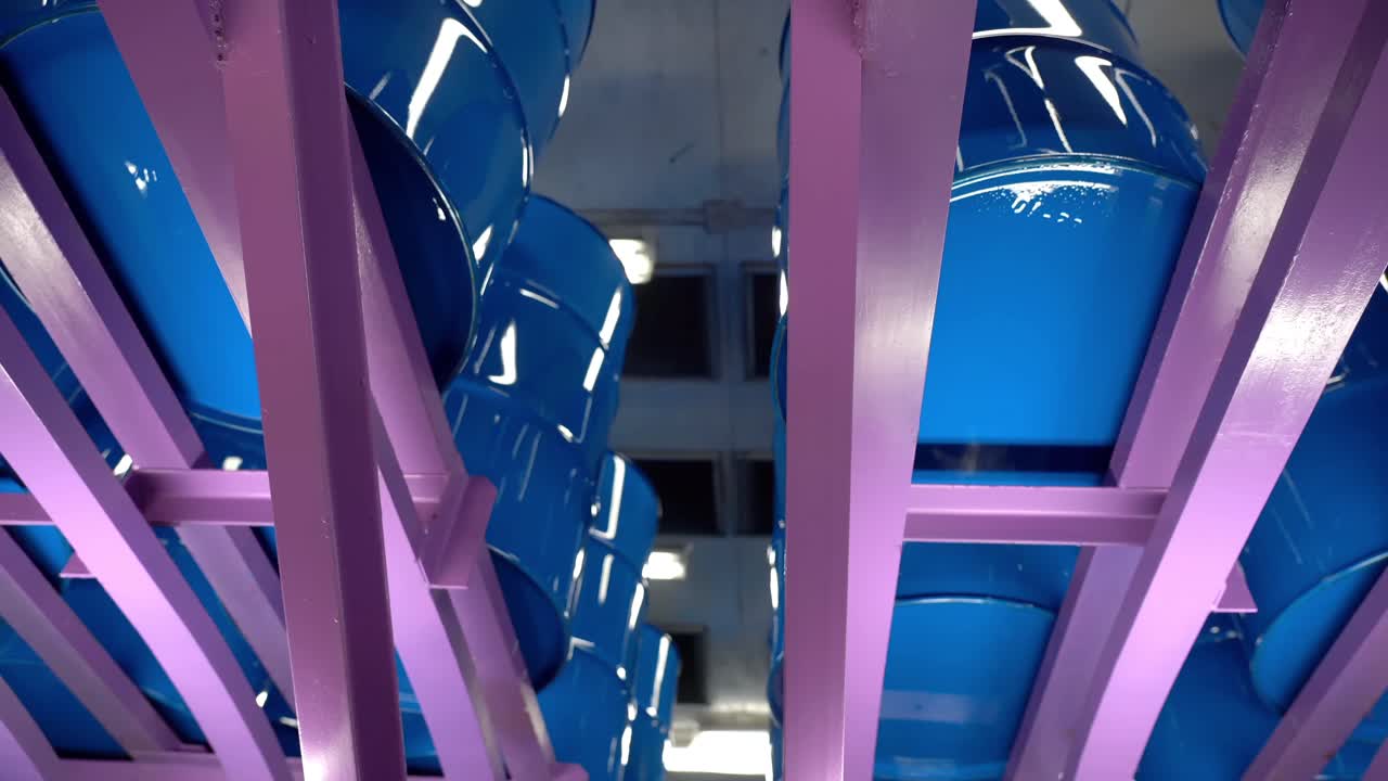 los tambores de acero estaban terminados y viajaban constantemente en un transportador para su posterior procesamiento.