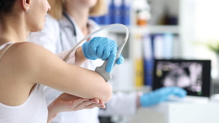 Doctor performing ultrasound on patient's elbow
