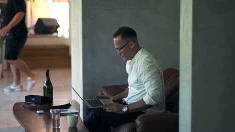 An-businessman-working-on-laptop-computer.-Male-professional-typing-on-laptop-keyboard-at-caffe.-Portrait-of-positive-business-man-looking-at-laptop-screen-indoors