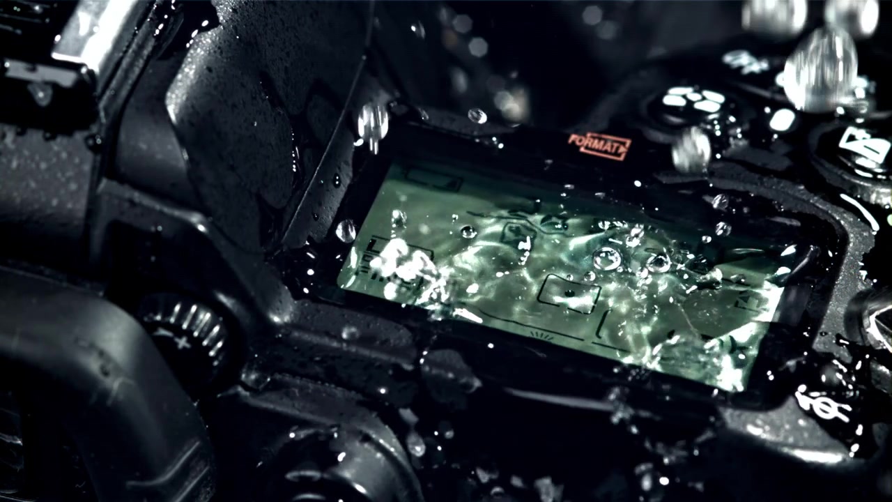 Primo piano di acqua che schizza sullo schermo superiore di una fotocamera digitale
