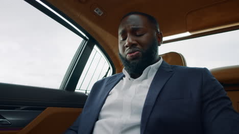 closeup african man reading documents at luxury car. businessman throwing papers