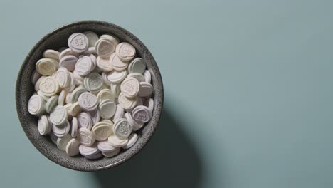 Heart-Candy-With-Romantic-Messages-Of-Love-Thrown-Into-Bowl-On-Blue-Background