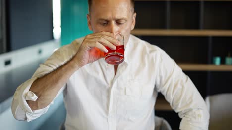 the man at the bar is drinking whiskey. close-up. slides a glass over the bar and hits the hand