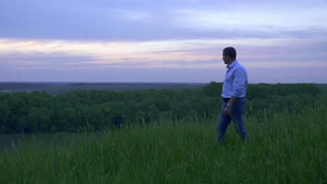 man contemplating sunset over a river valley