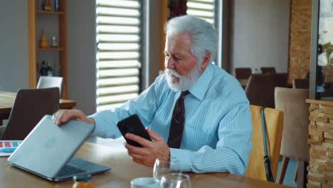 annoyed business owner talks on the phone and closes the laptop