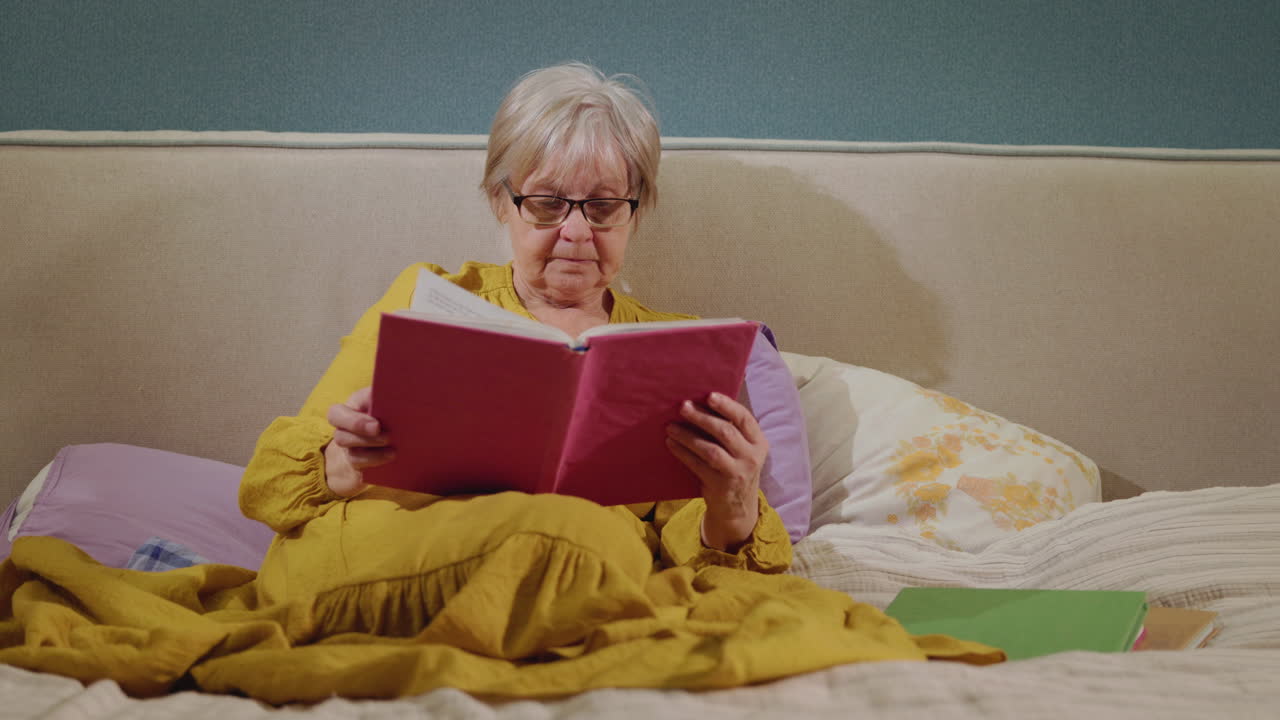 mujer mayor leyendo en la cama