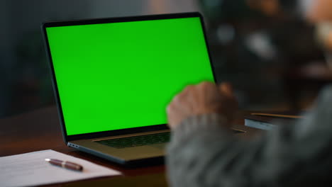 Chroma-key-computer-closeup.-Old-man-having-video-call-at-green-screen-laptop