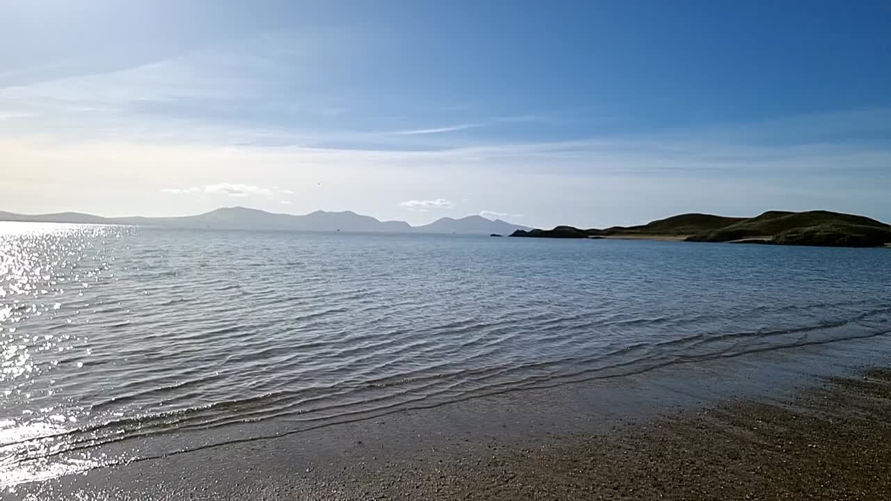 la nebulosa cordillera de snowdonia y ynys ilanddwyn a través de la idílica cámara lenta del brillante paisaje marino irlandés