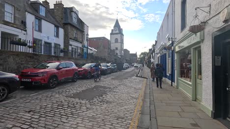 cyclist rides through historic edinburgh street