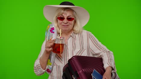 mature old woman tourist passenger drinking cocktail, dancing, holding passport, tickets, luggage