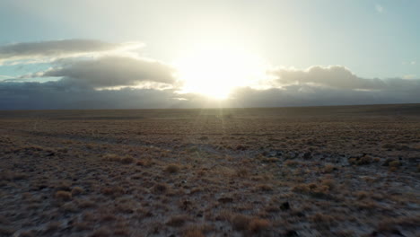 Low-sunrise-aerial-over-winter-desert-landscape-with-snow-flurries