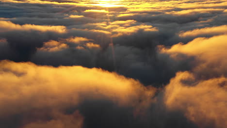 aerial, drone shot flying over sunlit clouds in hassell national park, during sunset, in west australia