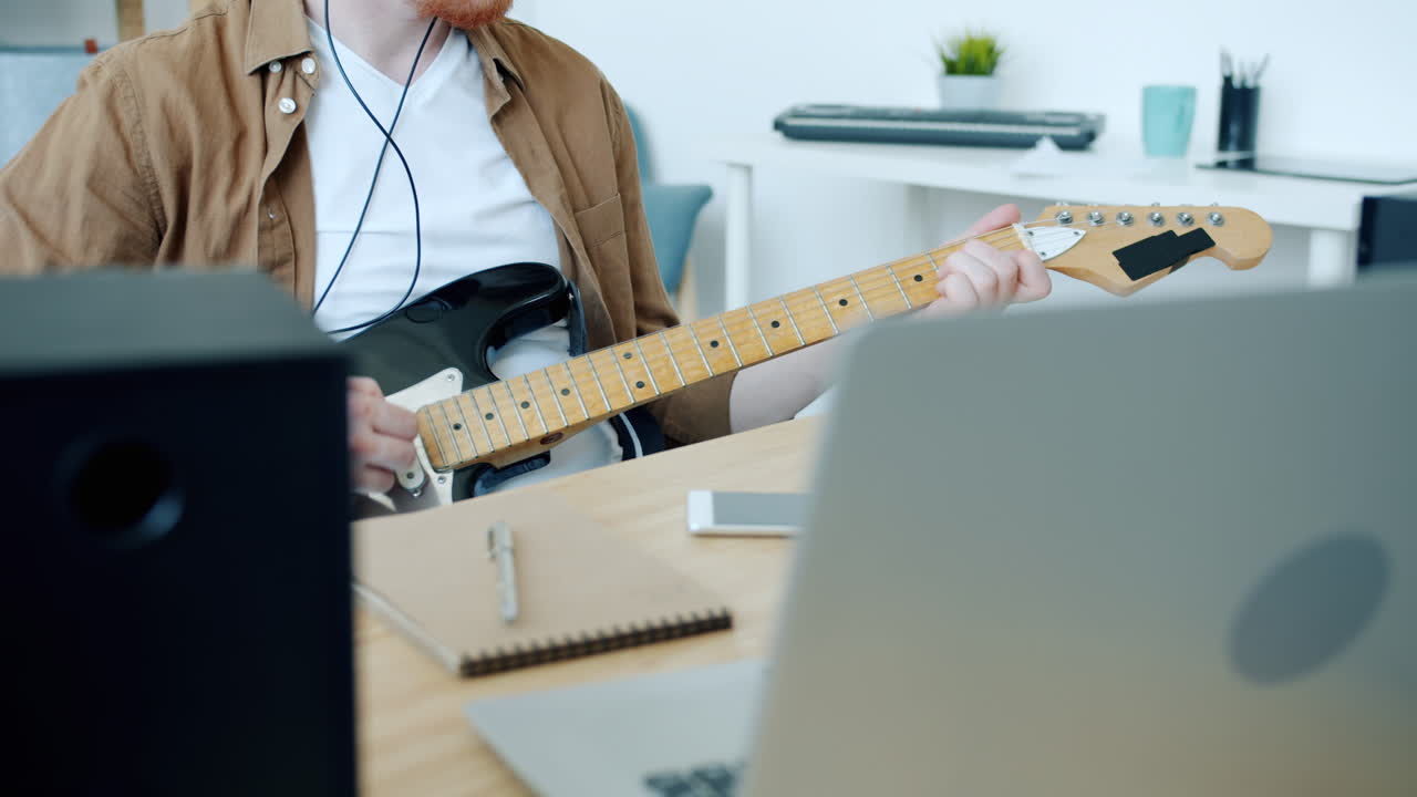 가정 스튜디오에서 전기 기타를 연주하는 남자