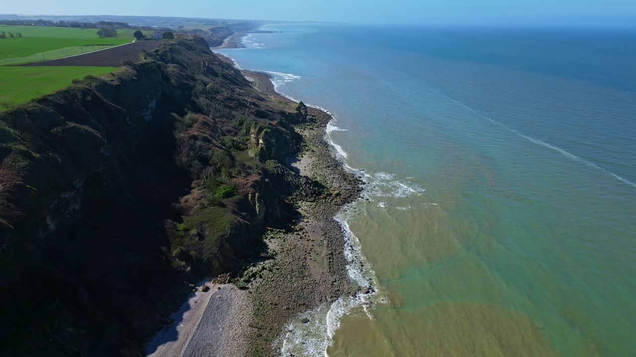 Cliffs and coastline at Longues-sur-Mer, Normandy, France. Aerial backward