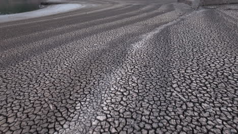 Land-with-dry-and-cracked-ground,-Sau-swamp-in-Catalonia,-Spain