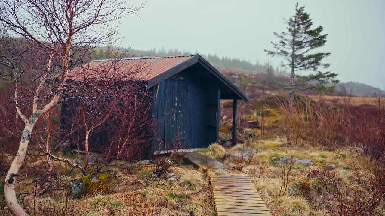 A Rustic Cabin Stands Quietly Amid the Misty, Rain-soaked Landscape of Reinsjøen, Åfjord, Trøndelag, Norway - Handheld Shot