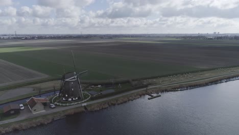 aerial drone shot of dutch windmill and farmland