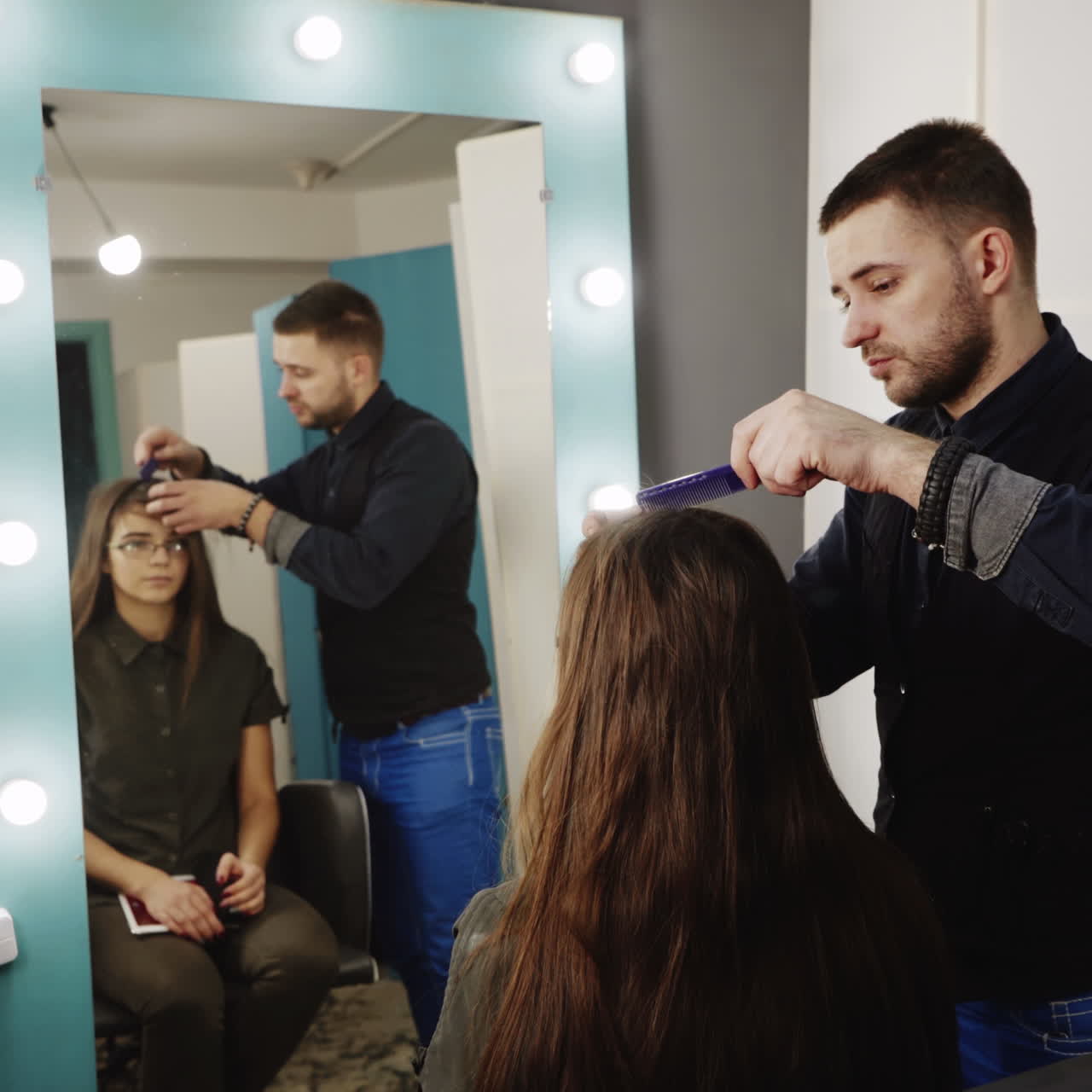 Male hairdresser combing client's hair before haircut at beauty parlor. Concept of beauty and hair care Square video