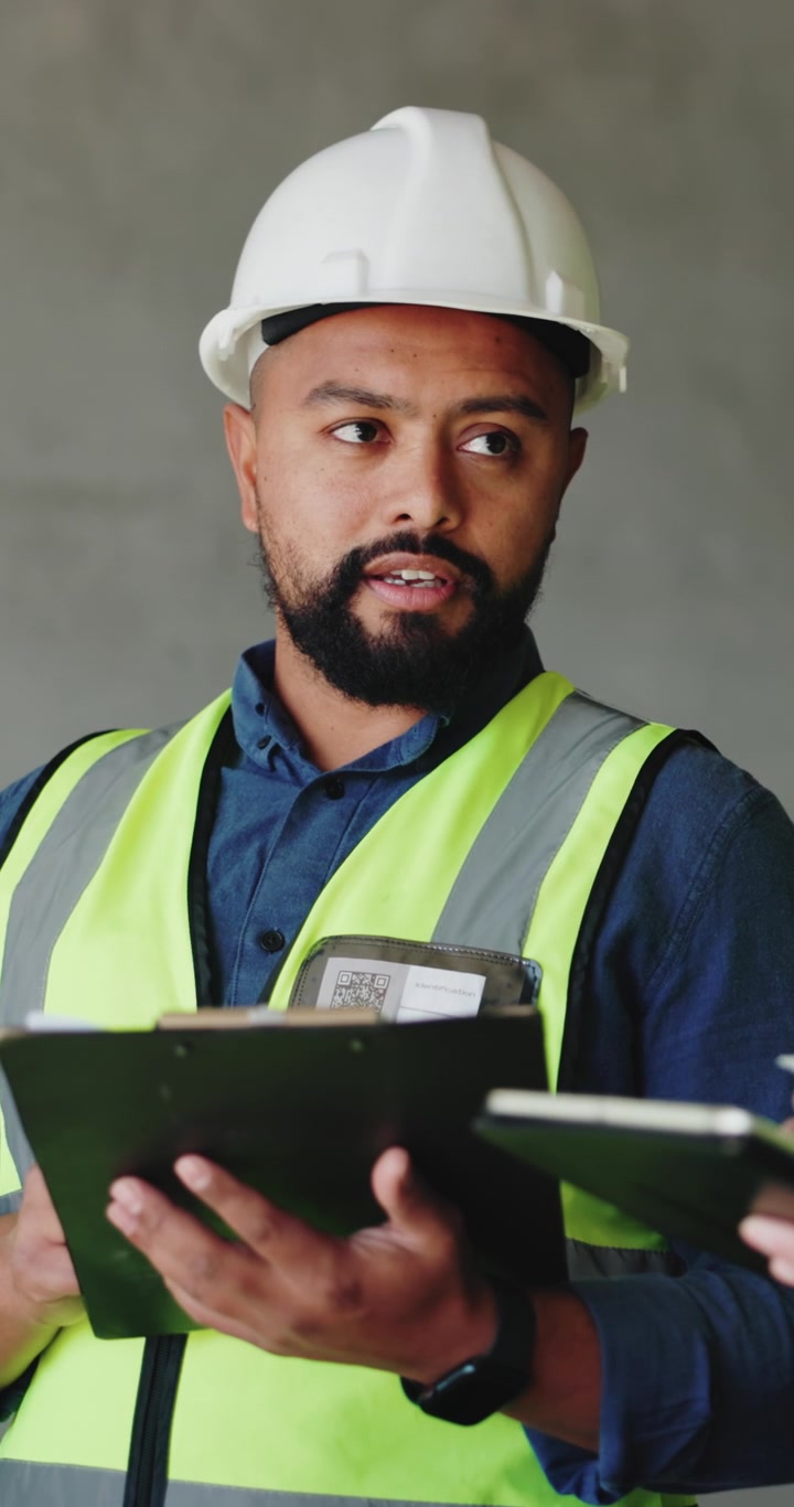 Direttore di cantiere edile che esamina documenti con una cartella portablocco