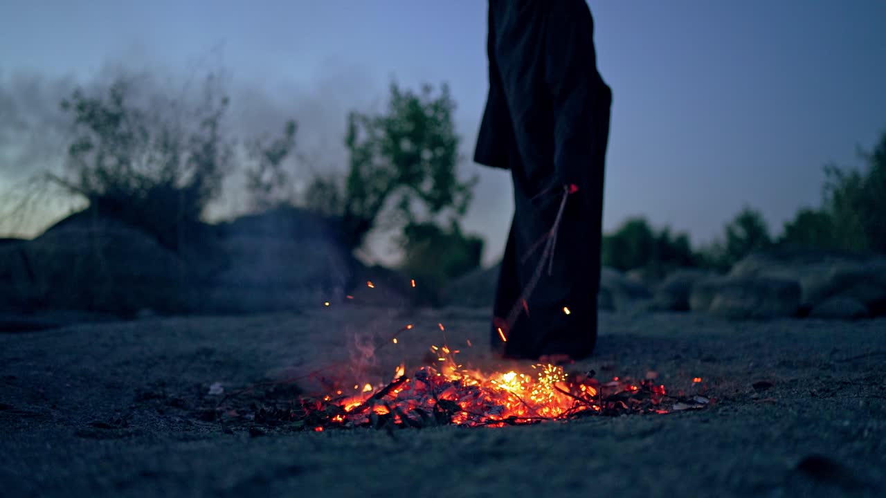 Witch at night forest. Witch conjuring in the forest conducts rituals with nature magic near fire