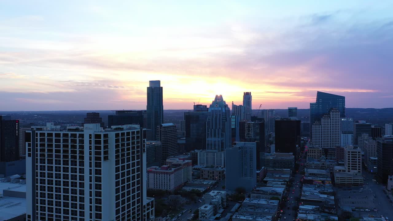 Drone flies toward the city during sunset