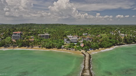 mirissa sri lanka aerial v1 sobrevuelo inverso puerto pesquero rompeolas secundario capturando el paisaje exótico de la playa de bandaramulla y los hoteles turísticos a lo largo de la costa - filmado con mavic 3 cine - abril 2023