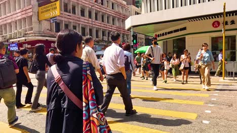 people crossing a bustling street in hong kong