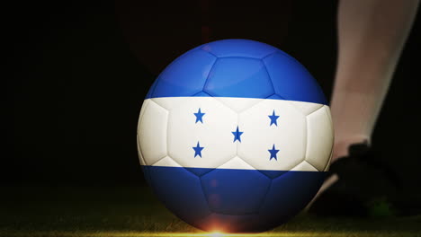 jugador de fútbol pateando la pelota de la bandera de honduras