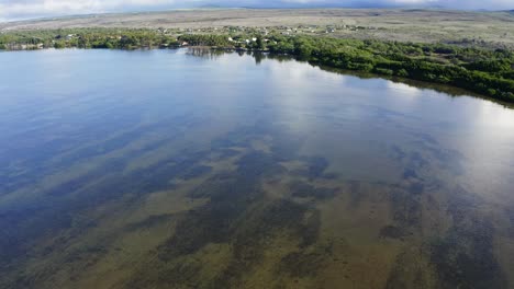 Excelente-Toma-Aérea-De-Una-Laguna-Por-Viviendas-Residenciales-En-La-Costa-De-Papohaku,-Hawaii