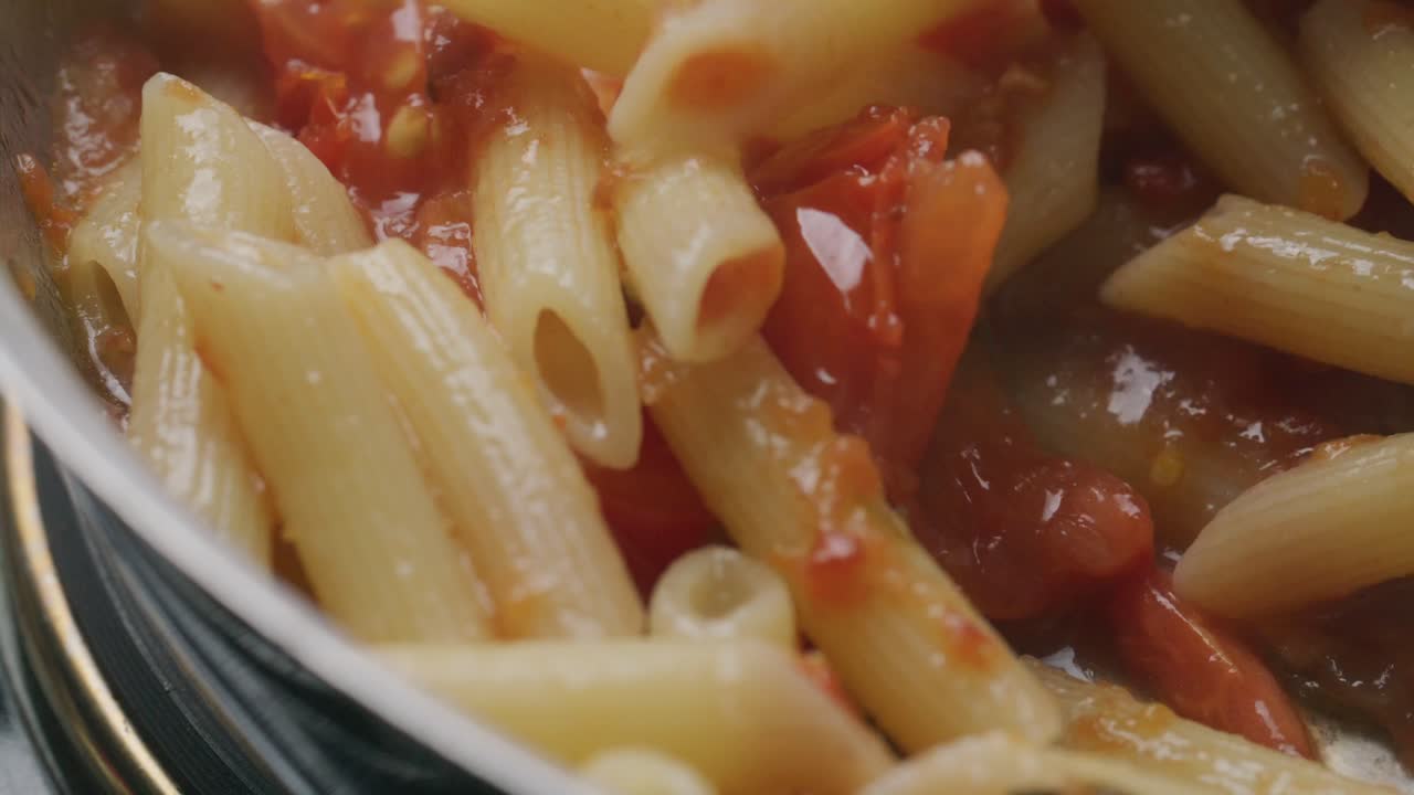 Cooking Penne Pasta with Rich Tomato Sauce in Pan