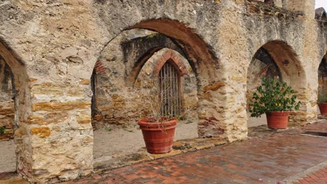 walking through old mission arches, plant pots and colorful brick work, stone and tiled floor