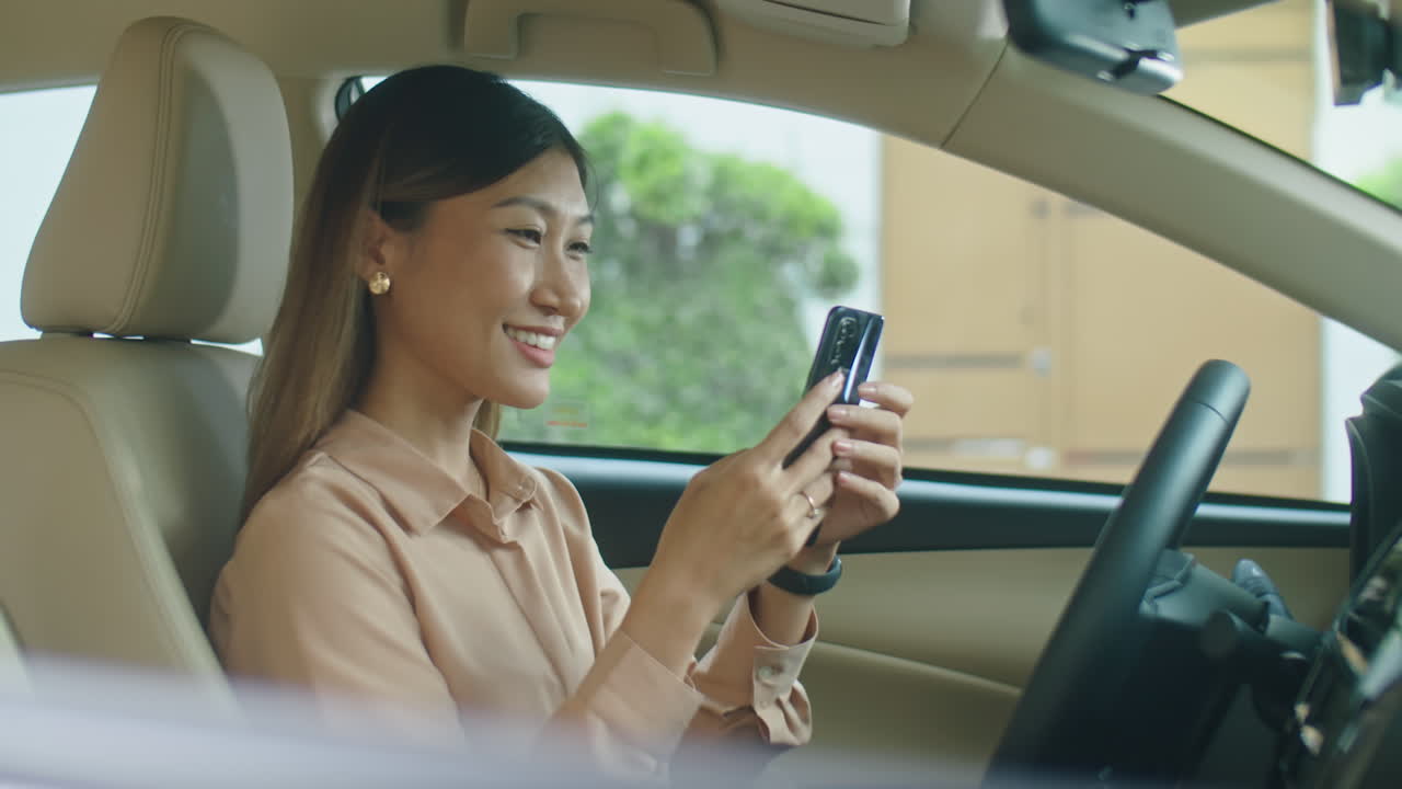 Asian Business Lady Having Phone Talk in Car