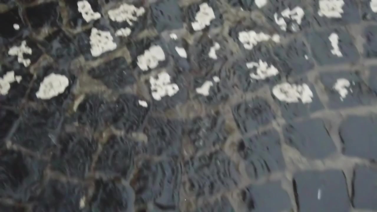 Pioggia in città. Le gocce di pioggia cadono sul marciapiede.