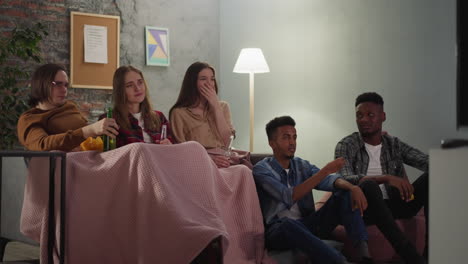 un grupo de hombres y mujeres jóvenes mira una película de melodrama