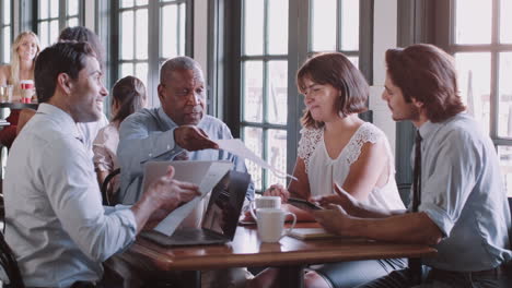 business team having informal meeting around table in coffee shop